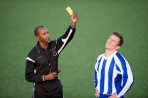 Soccer player receiving a yellow card from the match referee