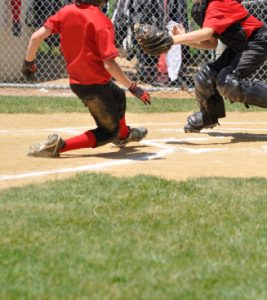 little league ball player sliding into home plate