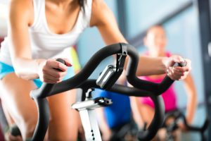 Woman exercises in spin class to lose weight