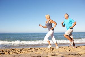 Older couple jogging beach