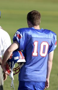 High school football player holding helmet