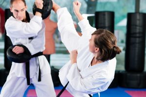 Tae kwon do fighter kicking with trainer